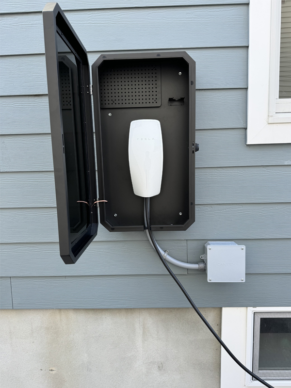 tesla charger installation, Electrician mounting EV charger beside driveway parking space at Asbury Park home